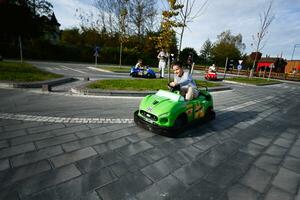 Garoto dirigindo corrida kart carro às diversão parque. foto