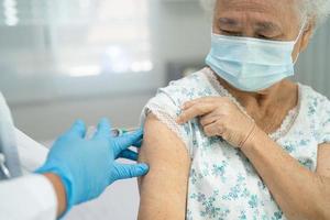 idosa asiática sênior usando máscara tomando vacina contra o coronavírus
