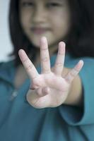 uma jovem contando o número com os dedos