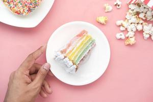 fatia de bolo de creme, donuts e pipoca na mesa foto