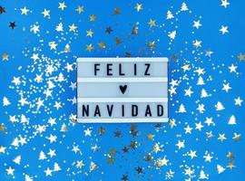 caixa de luz com a frase feliz navidad, feliz natal em espanhol no azul foto