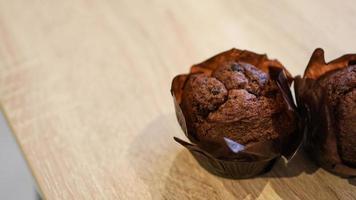 dois muffins de chocolate na mesa de madeira foto