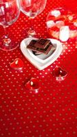 Dia dos Namorados. chocolate preto em um prato em forma de coração foto