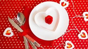 um prato branco com uma faca e um garfo em um fundo vermelho brilhante