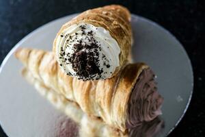 cremoso croissant com açoitado creme e chocolate em topo foto