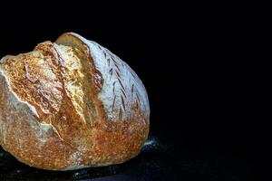 Vermont Preto farinha centeio pão com uma fresco crosta e poroso textura. recentemente cozido caseiro pão. uma sombrio temperamental. para texto. Alto qualidade fotografia. foto