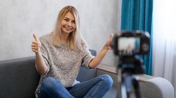 wwoman ou blogger com câmera gravando vídeo e mostrando o polegar para cima foto