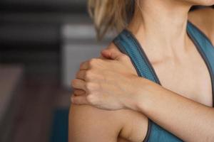 closeup em fitness mulher com dor no ombro foto