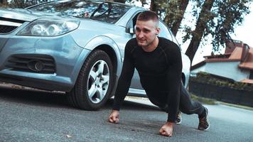 homem bonito perto do carro. o atleta torcido ao lado da máquina foto