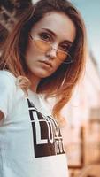 retrato da moda elegante mulher bonita em óculos de sol, posando na cidade foto