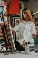 artista feminina com pincel na oficina de arte foto