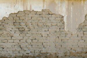 velho adobe construção parede com descascado fora gesso foto