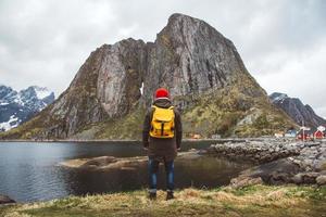 homem viajante com backpa de pé no fundo da montanha e do lago foto