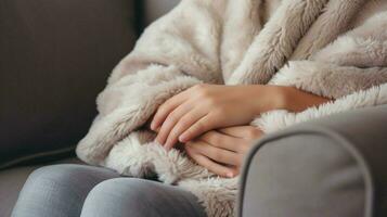 acolhedor lã cobertor em sofá mão segurando travesseiro para relaxamento foto