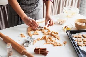 mulher com as mãos assando biscoitos na cozinha foto