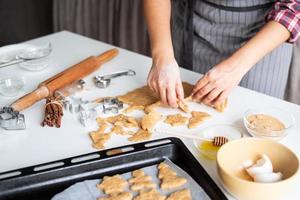 mulher com as mãos assando biscoitos na cozinha foto