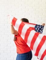 bela jovem com bandeira americana, vista traseira foto