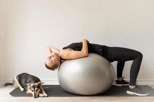 mulher deitada na bola de fitness aquecendo antes do treino foto