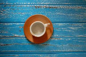 xícara de café vazia em uma mesa de madeira rural azul foto