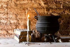 soletrar do bruxa noite com velas e Panela com fogo entre teias de aranha e antigo terra foto