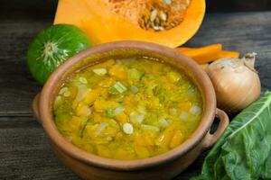 caçarola com quente vegetal sopa e Grato queijo em rústico madeira foto