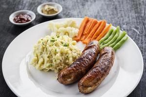 linguiça alemã com purê de batata e refeição simples de vegetais