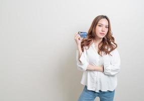 mulher asiática segurando um cartão de crédito foto