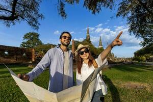 casal do turista venha para Visita às wat phra si Sanphet têmpora, Ayutthaya Tailândia usando mapas para viagem, férias, feriado, lua de mel e turismo foto