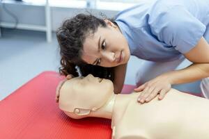 mulher praticando cpr técnica em manequim durante primeiro ajuda treinamento. primeiro ajuda Treinamento - cardiopulmonar ressuscitação. primeiro ajuda curso em cpr fictício. foto