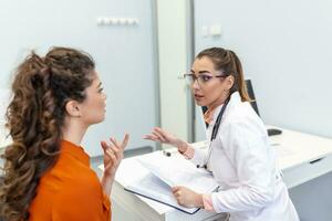 jovem fêmea profissional médico médico consultando paciente, falando para adulto mulher cliente às médico checar Visita. doenças tratamento. médico saúde Cuidado conceito foto