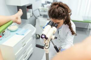 colposcópio fechar-se, imagem do uma ginecologista e uma paciente dentro uma ginecológico cadeira. mulheres consulta foto