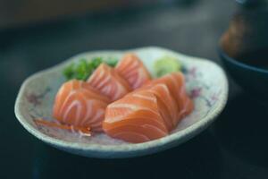 delicioso sashimi salmão servido com wasabi em branco prato foto