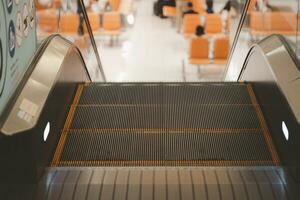 moderno escada rolante dentro a aeroporto com esperando assento fundo. raso profundidade do campo foto