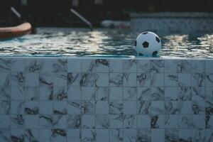 inflável futebol bola flutuando dentro a natação piscina foto