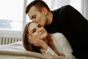 casal de negócios na cama em quarto de hotel foto