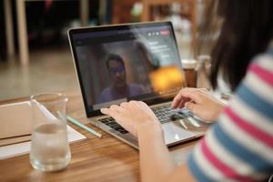 mulher asiática usando laptop para trabalhar em casa e reunião on-line. foto