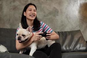 jovem está jogando videogame com seu cachorro fofo. foto