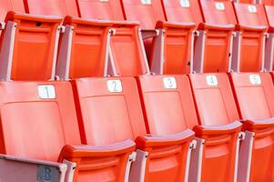 esvaziar laranja assentos às estádio, linhas do assento em uma futebol estádio foto