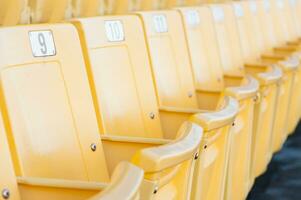 esvaziar amarelo assentos às estádio, linhas do assento em uma futebol estádio, selecione foco foto