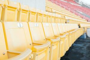 esvaziar amarelo assentos às estádio, linhas do assento em uma futebol estádio, selecione foco foto