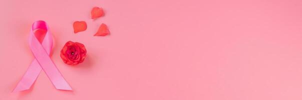 Mês de conscientização do câncer de mama. fita rosa e flor em fundo colorido. conceito de saúde da mulher. símbolo de esperança e apoio. foto