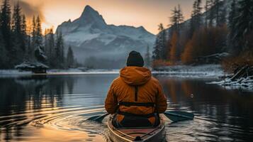 homem caiaque em a lago dentro a canadense montanhas rochosas às nascer do sol. foto