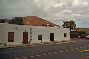 cenário com a da cidade característica branco edifícios a partir de a espanhol ilha do Lanzarote em uma caloroso verão dia foto