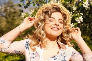 mulher sorridente de verão com chapéu de palha no parque foto
