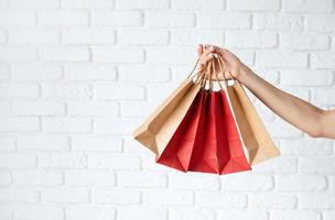 mão de uma mulher com sacolas de compras, texto preto sexta-feira em saco de papel foto