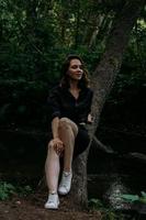 mulher com roupas pretas em uma floresta escura de coníferas. rastreamento e viagem foto