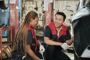 profissional masculino automotivo Supervisor treinado Preto fêmea mecânico técnico para parafuso carro roda nozes para reparar às garagem, veículo manutenção serviço trabalho indústria ocupação o negócio empregos. foto