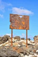 uma oxidado placa em a de praia dentro a meio do a deserto foto
