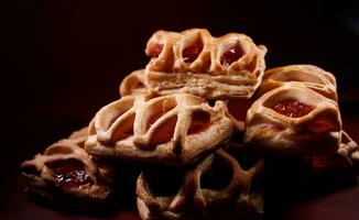 sopro pastelaria pastelaria com amora silvestre geléia em uma Sombrio vermelho fundo. biscoitos com amora silvestre geléia. foto