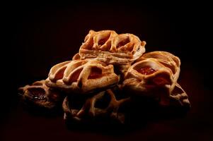 sopro pastelaria pastelaria com amora silvestre geléia em uma Sombrio vermelho fundo. biscoitos com amora silvestre geléia. foto